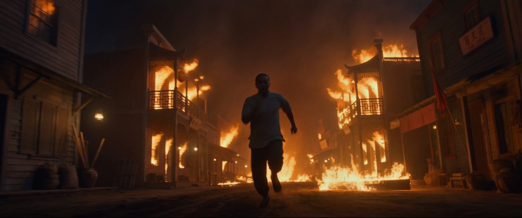 Gum Shan: a man runs down a burning street at night